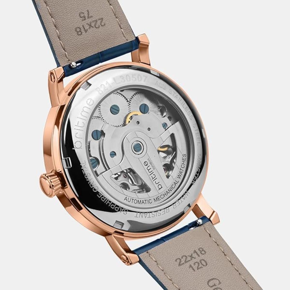 Close-up of a mechanical watch with visible brand name on a light gray background