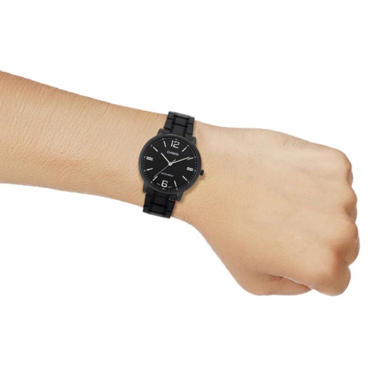 Black wristwatch on a wrist with a white background