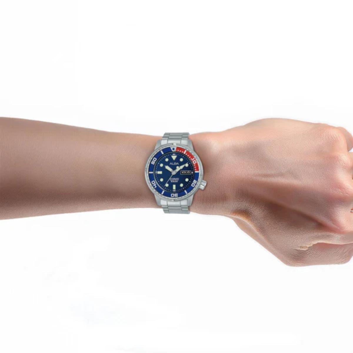 Wrist wearing a silver watch with a blue face on a white background