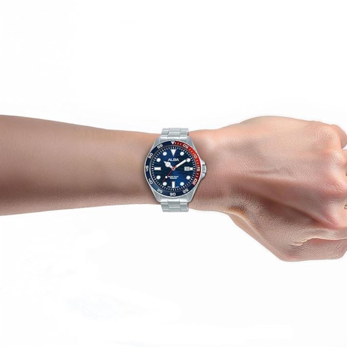 Wrist wearing a watch with a blue face and silver case on a white background