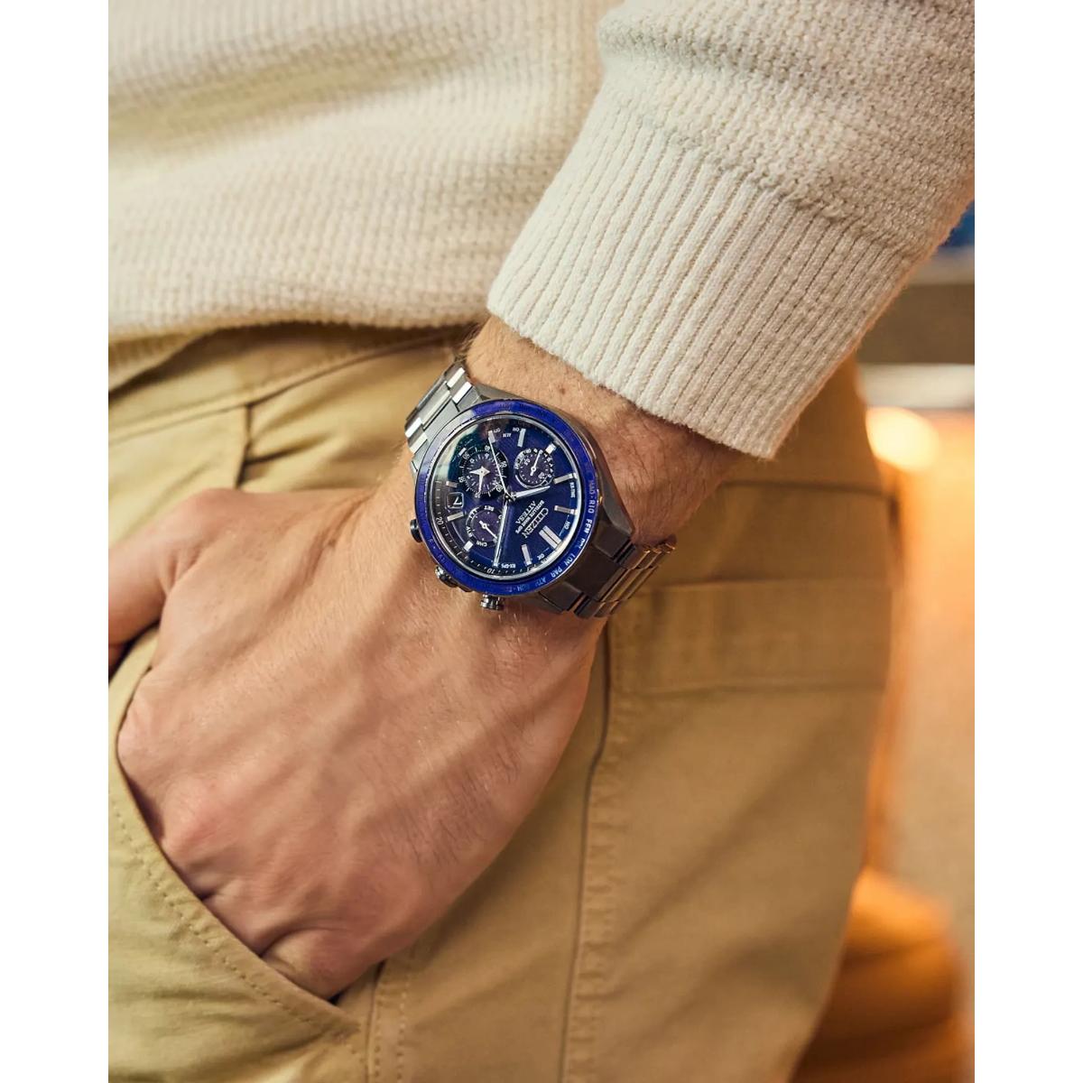 Person wearing a watch with a blue face on a blurred background
