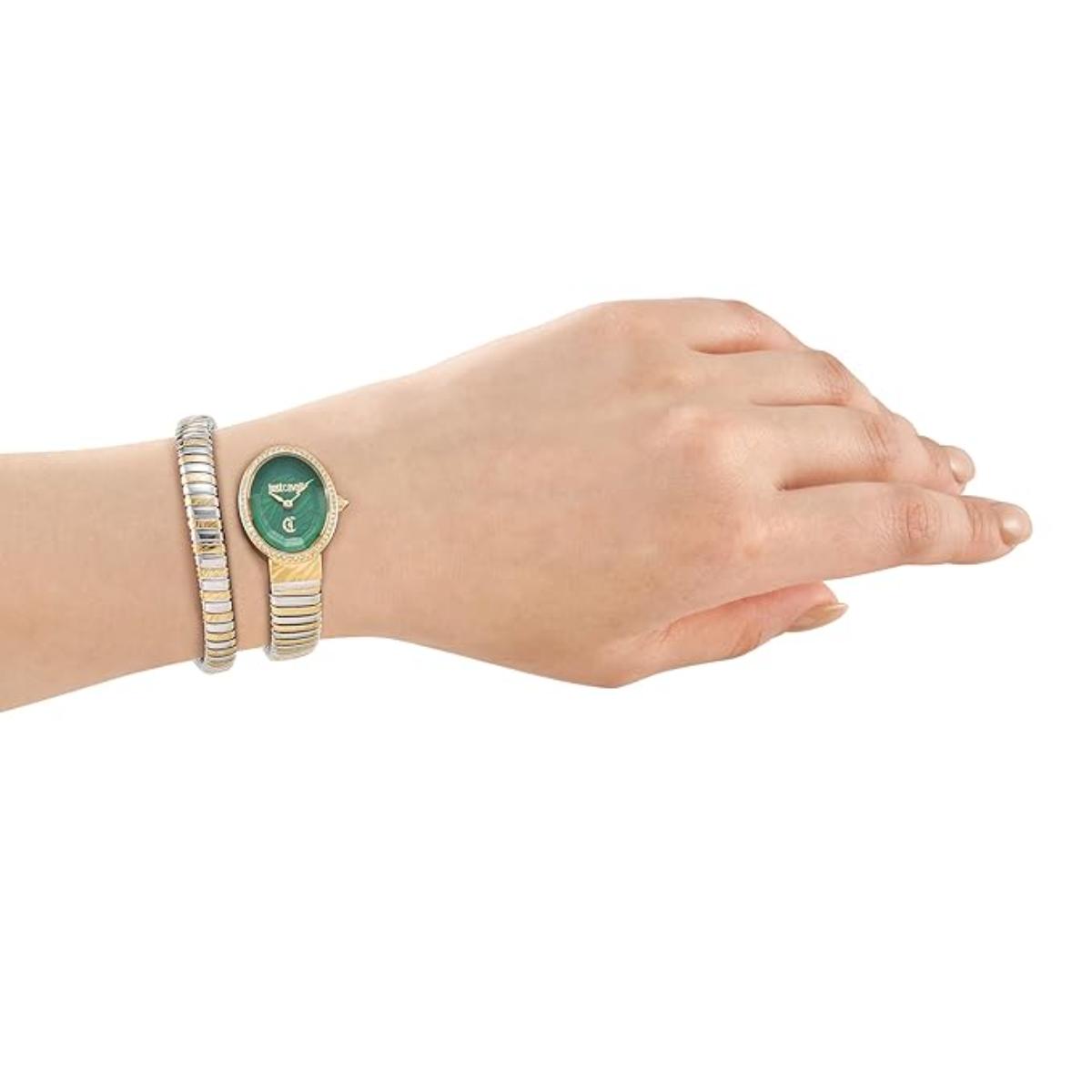 Hand wearing a green watch with gold accents on a white background