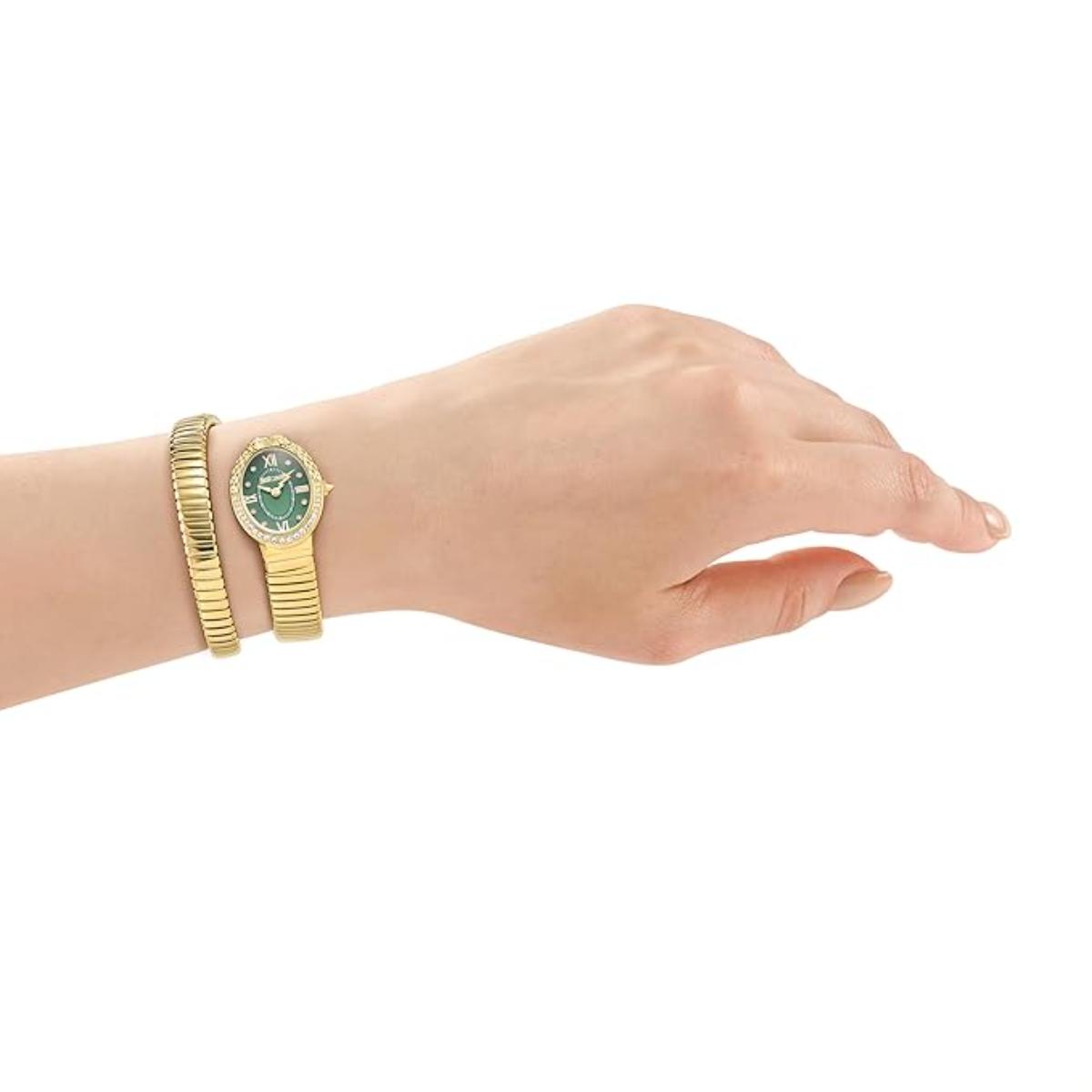 Gold watch and bracelet on a wrist against a white background