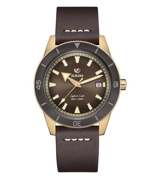 A bronze-colored Rado Captain Cook automatic watch with a brown leather band and a dark brown dial.