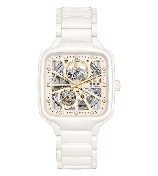 A white ceramic Rado True Square Automatic Open Heart unisex watch with a gold-colored dial and visible mechanical components.
