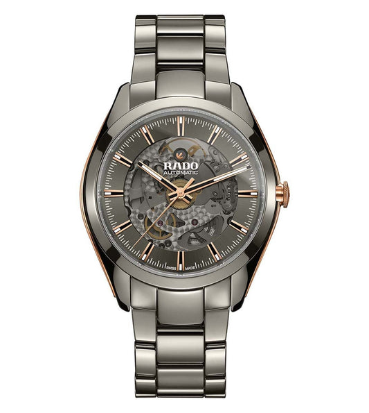 A Rado HyperChrome Automatic Open Heart watch with a silver bracelet and a silver case, featuring a gray dial and rose gold accents.