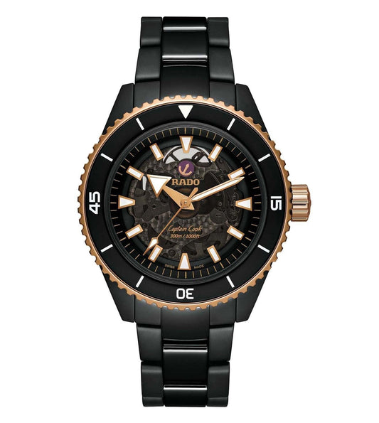 A black Rado Captain Cook HT Ceramic watch with a rose gold dial and hands, and a black bracelet.