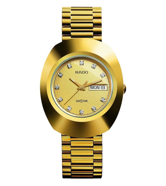 A gold-colored RADO Original watch with a dial featuring diamond-like accents and a day and date display, accompanied by a matching gold bracelet.