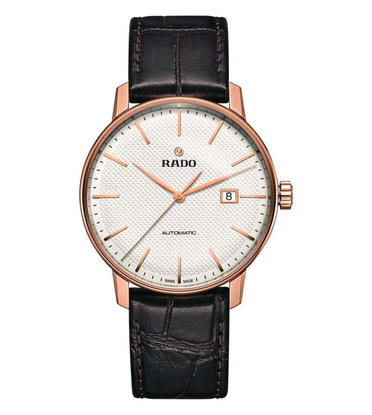 A Rado Coupole Classic Automatic watch with a rose gold case, white dial, and black leather strap.