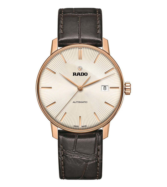 A Rado Coupole Classic Automatic watch with a rose gold case, a beige dial, and a brown leather strap.
