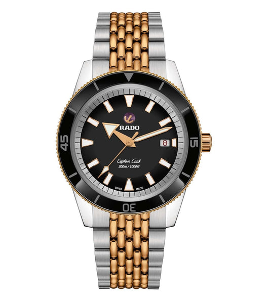 A Rado Captain Cook watch for men with a black dial, gold-colored bezel, and a silver metal band.