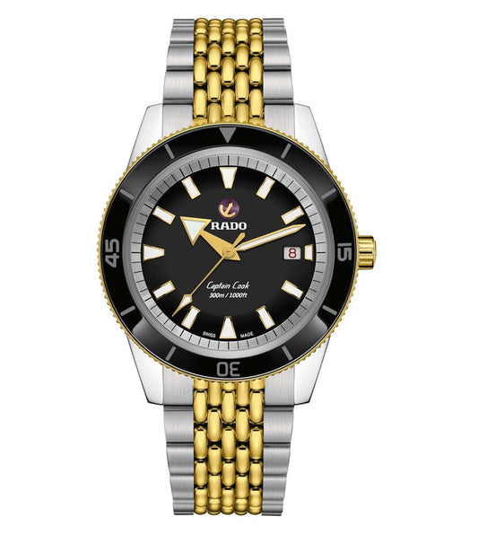 A Rado Captain Cook Automatic watch with a black dial, gold bracelet, and black casing.