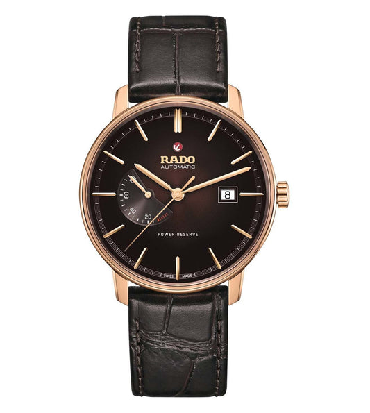 A Rado Coupole Classic Unisex Watch with a brown leather band and rose gold case, featuring a black dial and sapphire crystal.