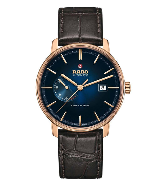 A Rado Coupole Classic Unisex Watch with a blue dial, rose gold case, and a brown leather strap.
