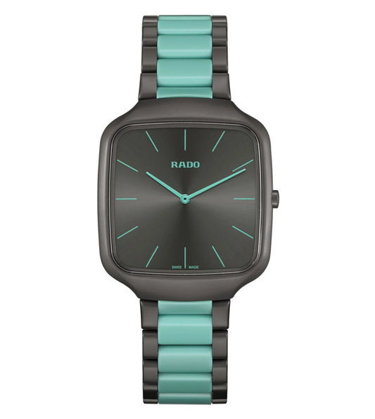 A Rado True Square Thinline X Les Couleurs Le Corbusier analog unisex watch with a matte iron grey case, English green accents on the bracelet and dial, and a sun brushed iron grey dial.