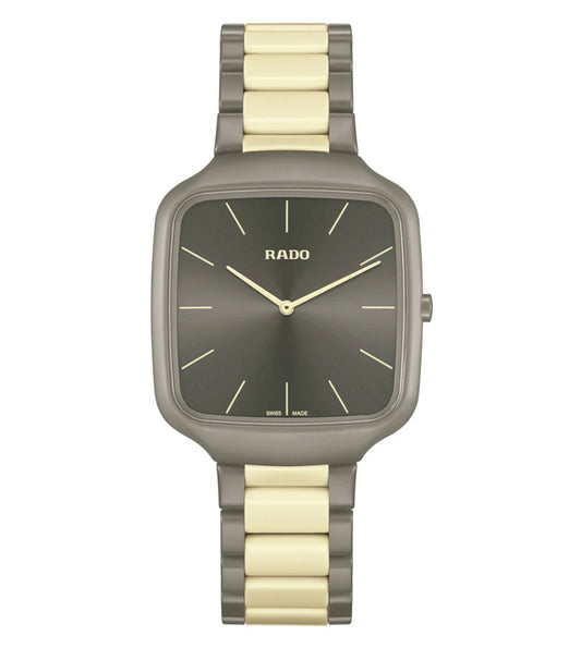 A Rado True Square Thinline X Les Couleurs Le Corbusier analog unisex watch with a matte grey brown case and gold-tone bracelet.