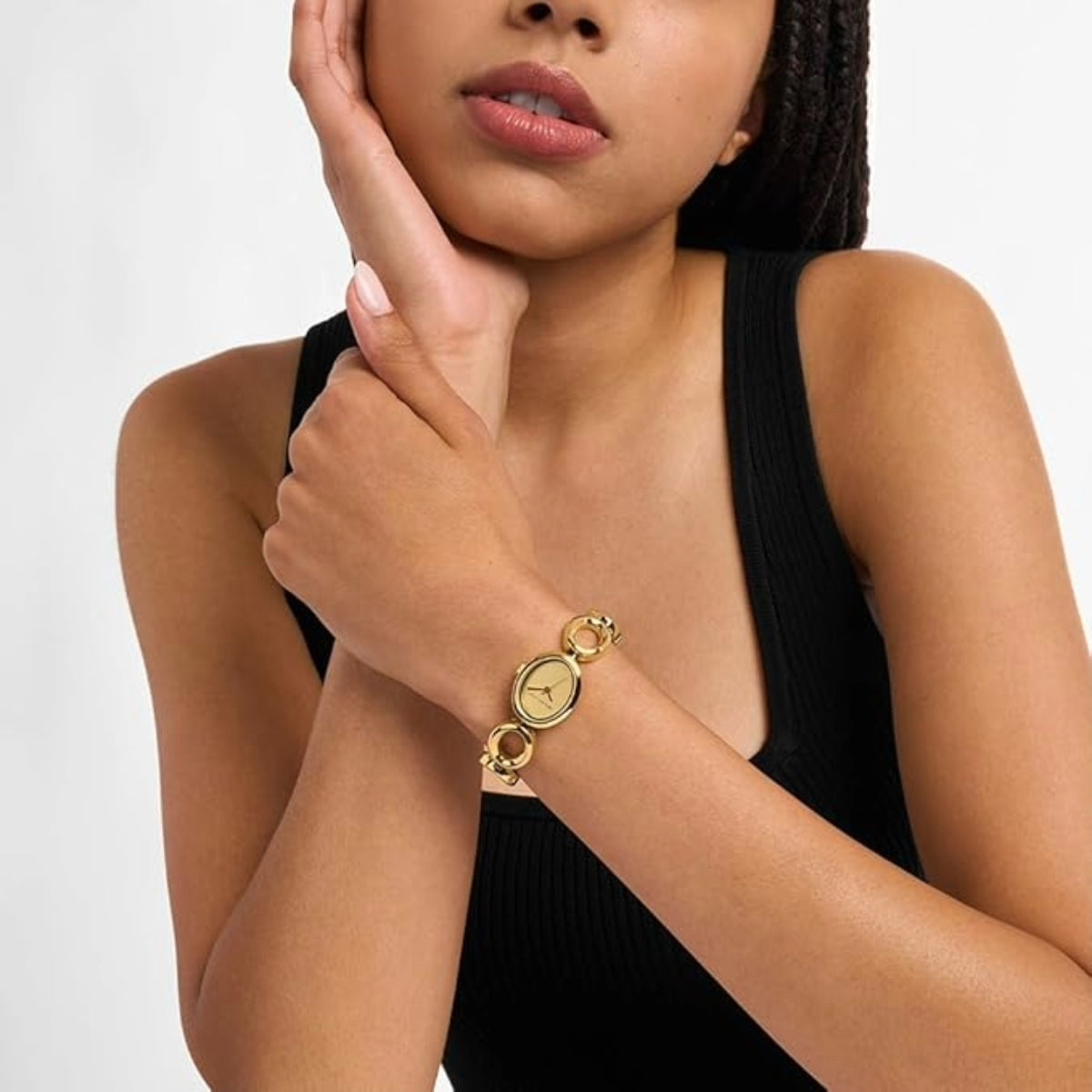 Woman wearing a gold bracelet on a plain background