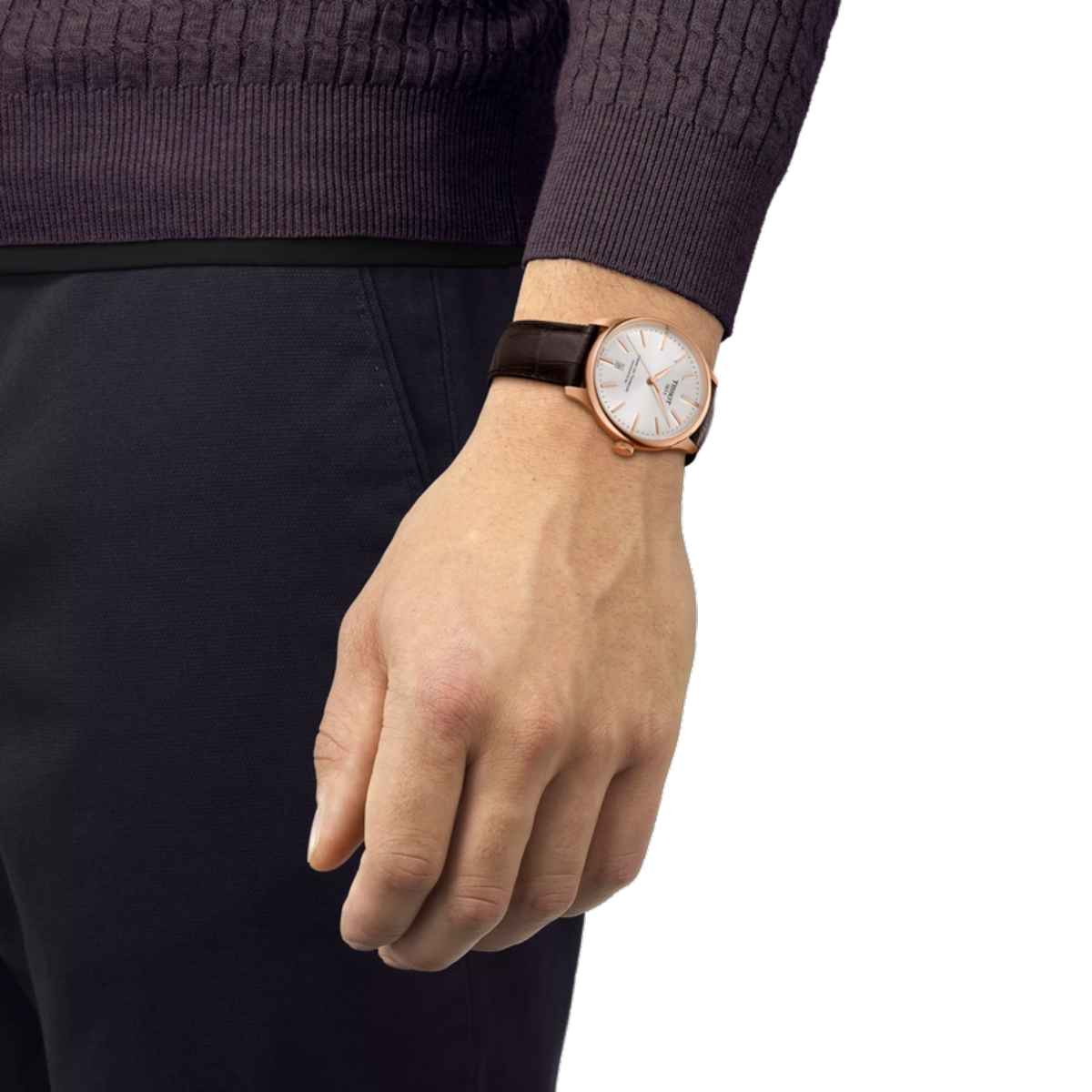 Hand wearing a watch with a white dial and brown strap on a plain background