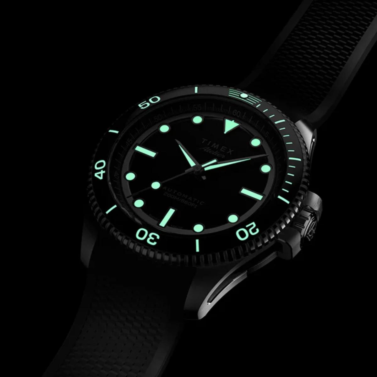 Timex watch with green glowing face on a black background