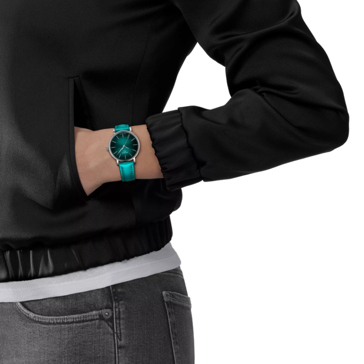 Person wearing a black jacket and gray jeans with a turquoise watch on a white background