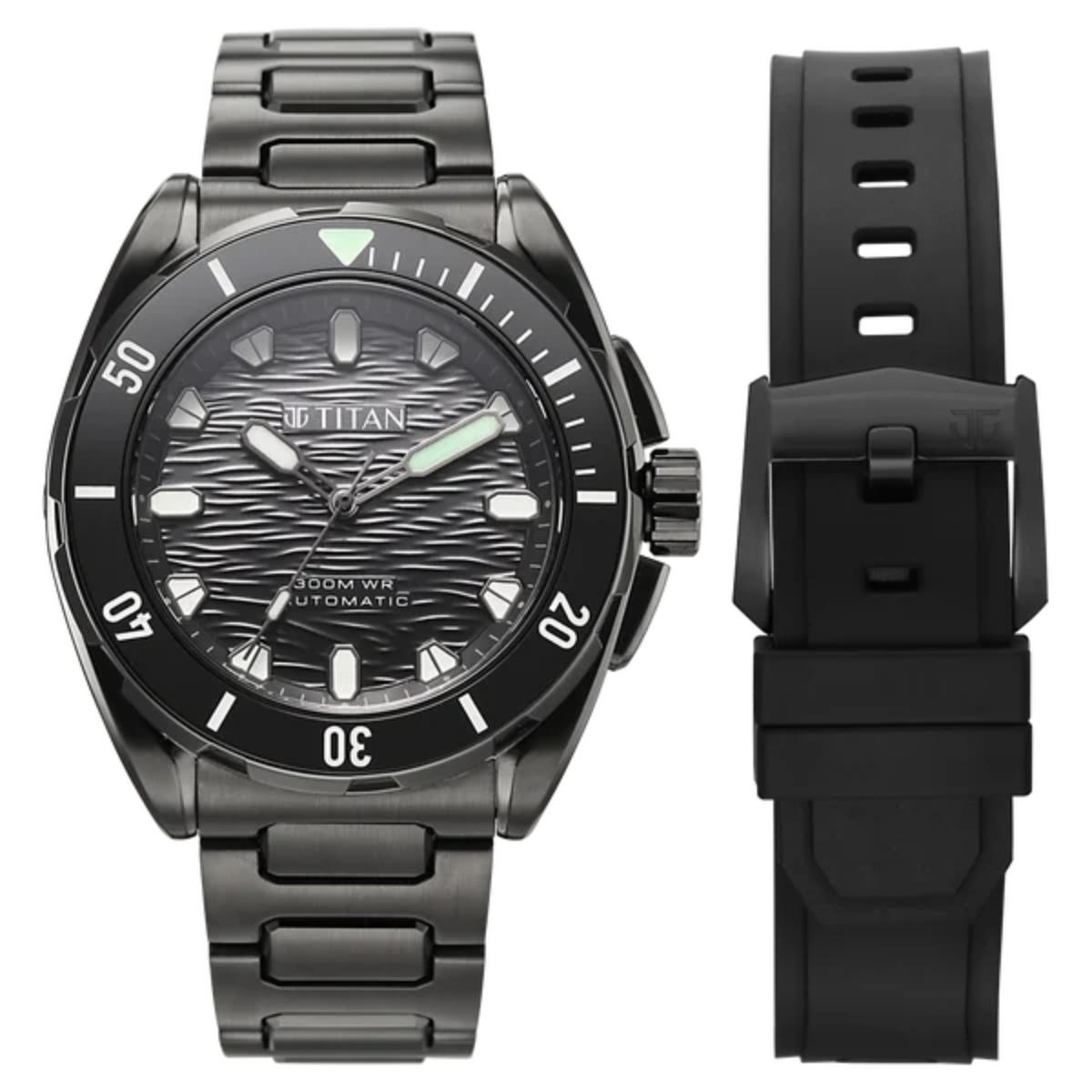 A black titanium automatic watch with a textured dark dial, black bezel, and matching black metal link bracelet, shown alongside a separate black silicone strap on a white background.
