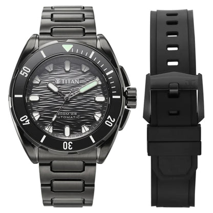 A black titanium automatic watch with a textured dark dial, black bezel, and matching black metal link bracelet, shown alongside a separate black silicone strap on a white background.