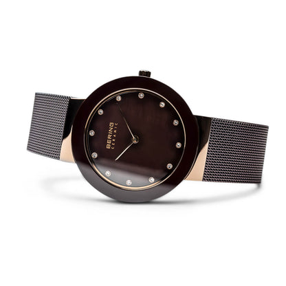 Wristwatch with brown dial and black mesh strap on a white background