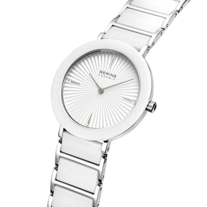 Silver watch with a detailed face on a light gray background