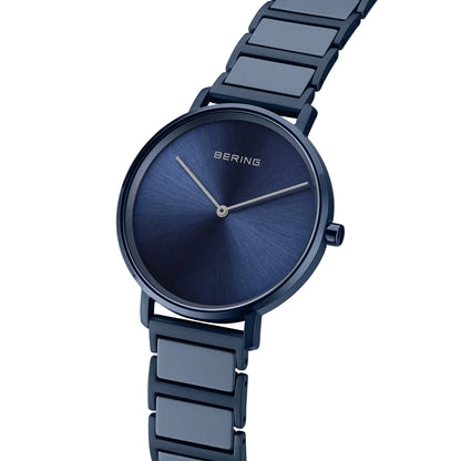 Blue watch with metal strap on a light blue background