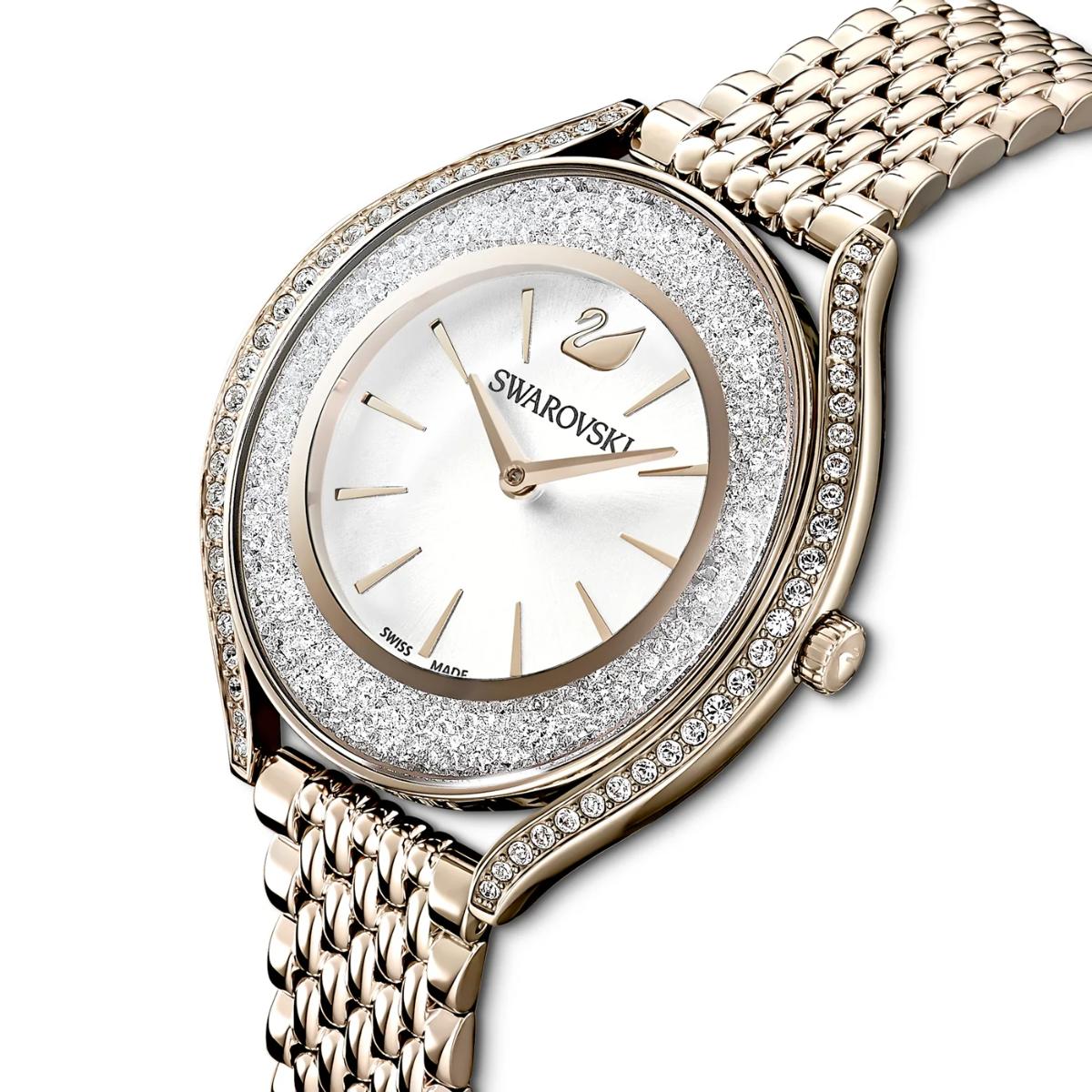 Gold Swarovski watch with sparkling bezel on a white background