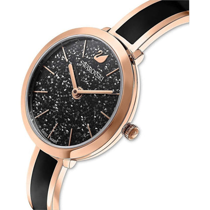 Swarovski watch with black face and rose gold case on a white background