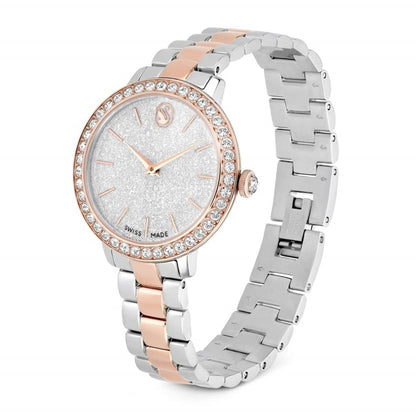 Silver and rose gold watch with gemstone-encrusted face on a white background