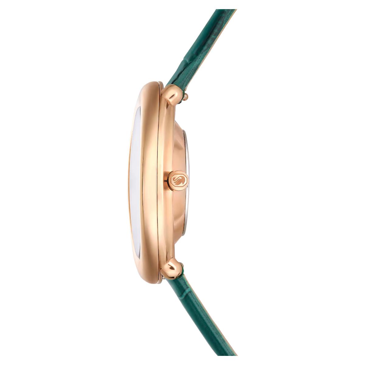 Close-up of a watch with a green strap and rose gold case on a white background