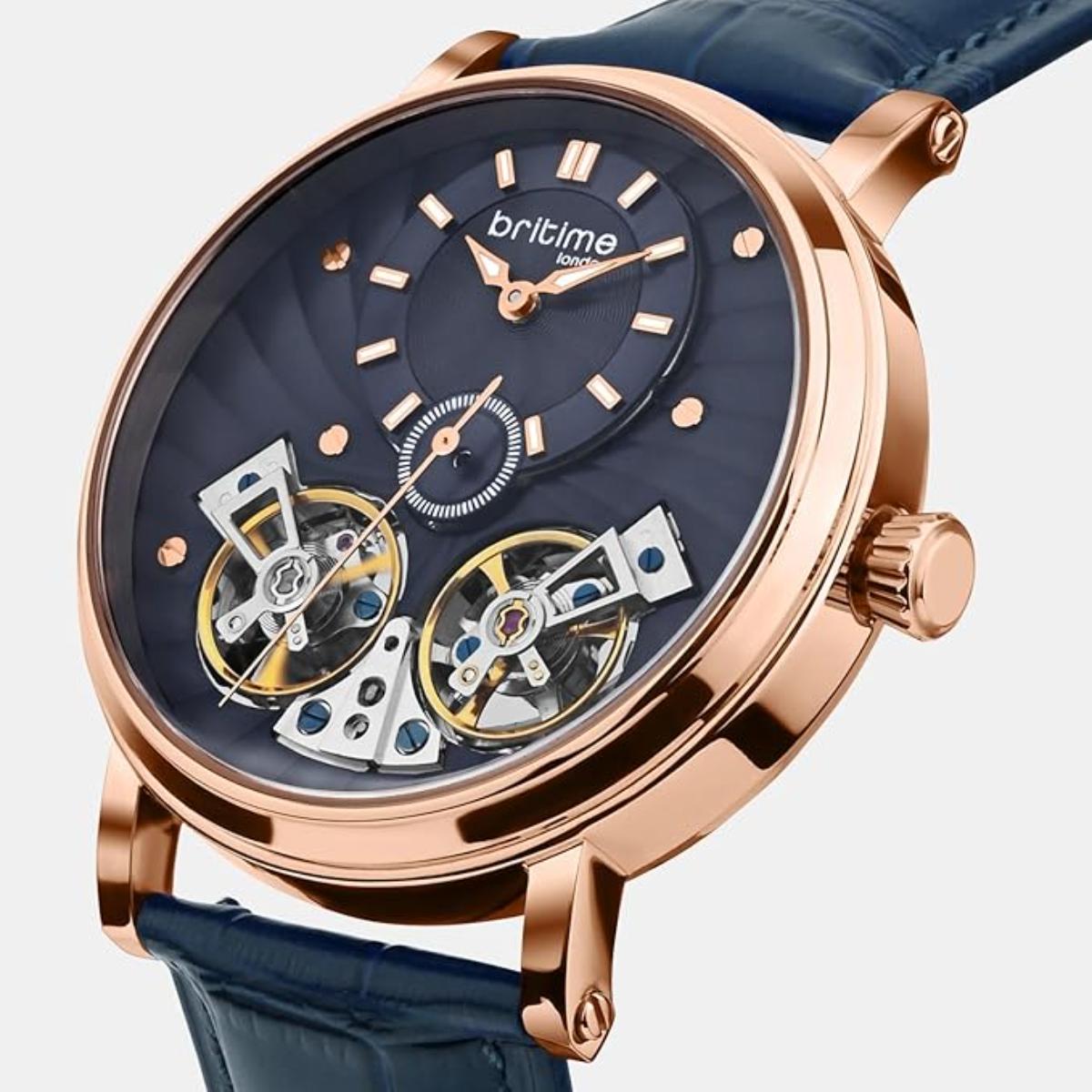 Luxury watch with rose gold case and blue strap on a light gray background