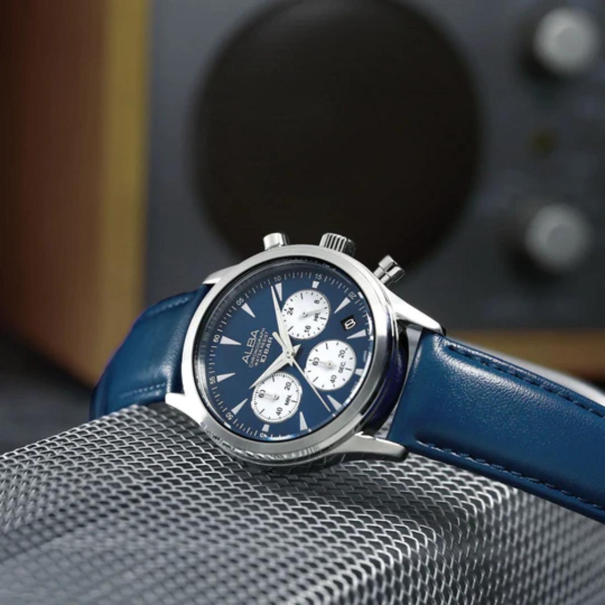 Blue watch with a silver case on a textured surface
