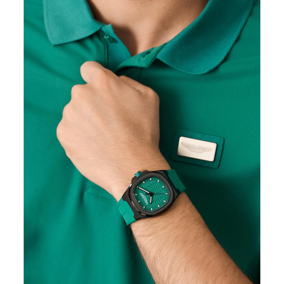 Person wearing a green watch with a matching shirt, featuring a visible brand logo.