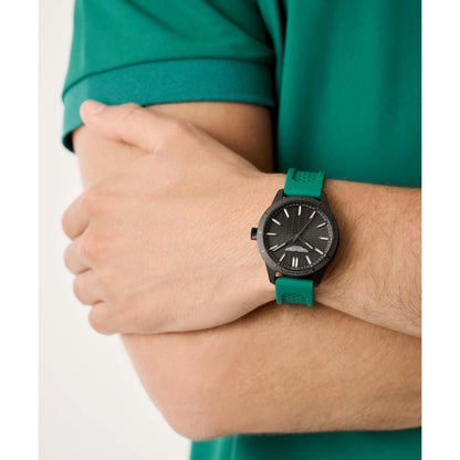 Person wearing a watch with a green strap on a white background