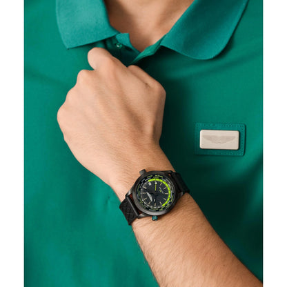 Person wearing a green polo shirt with a brand logo and a black wristwatch.