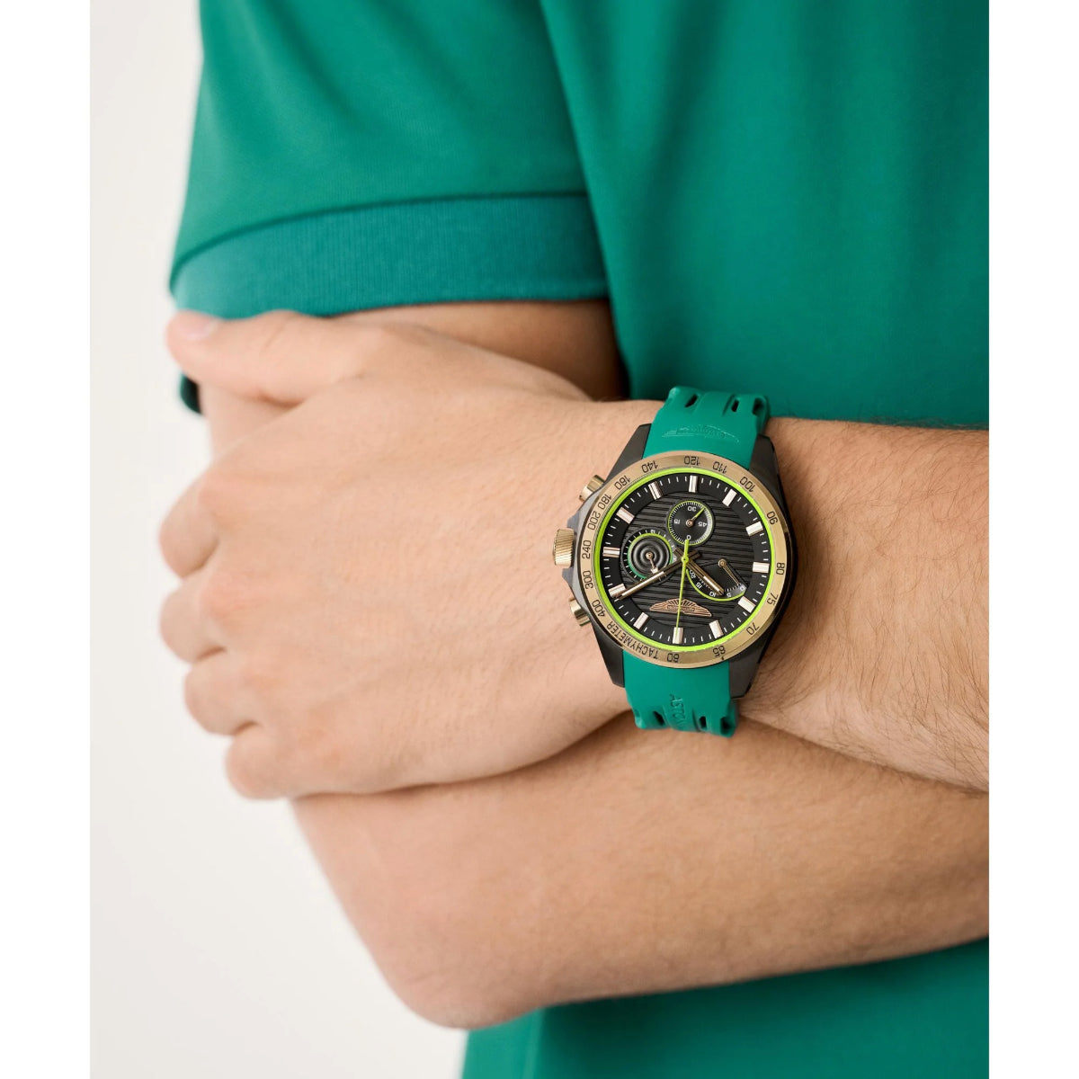 Person wearing a green watch with a detailed face on a white background