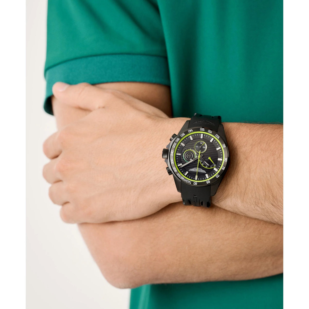 Person wearing a black watch with a green accent on a white background