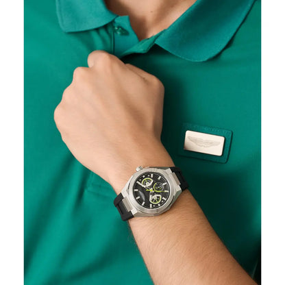 Person wearing a green shirt with a brand logo, adjusting their wristwatch.