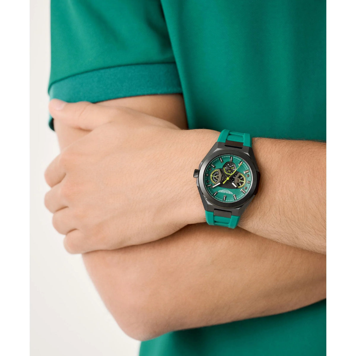 Person wearing a green watch with a matching shirt on a white background
