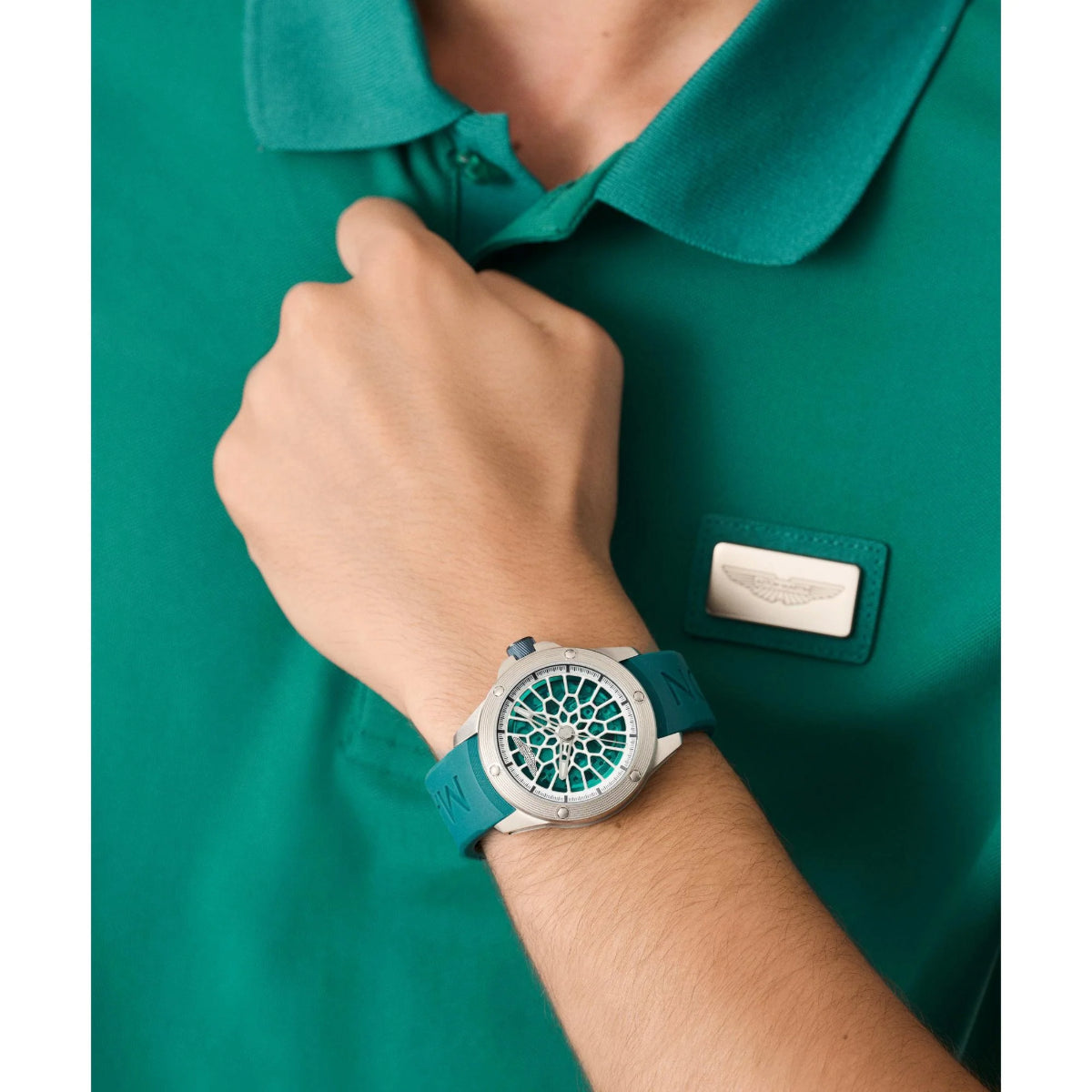 Person wearing a green watch with a detailed face on a green shirt background