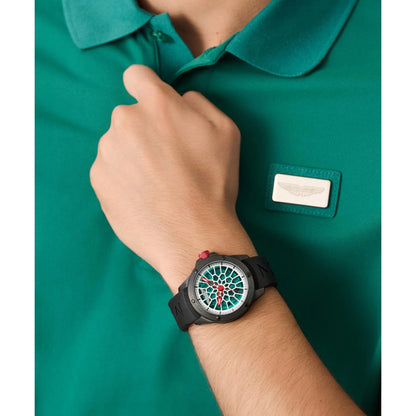 Person wearing a green polo shirt with a name tag and a watch on a white background