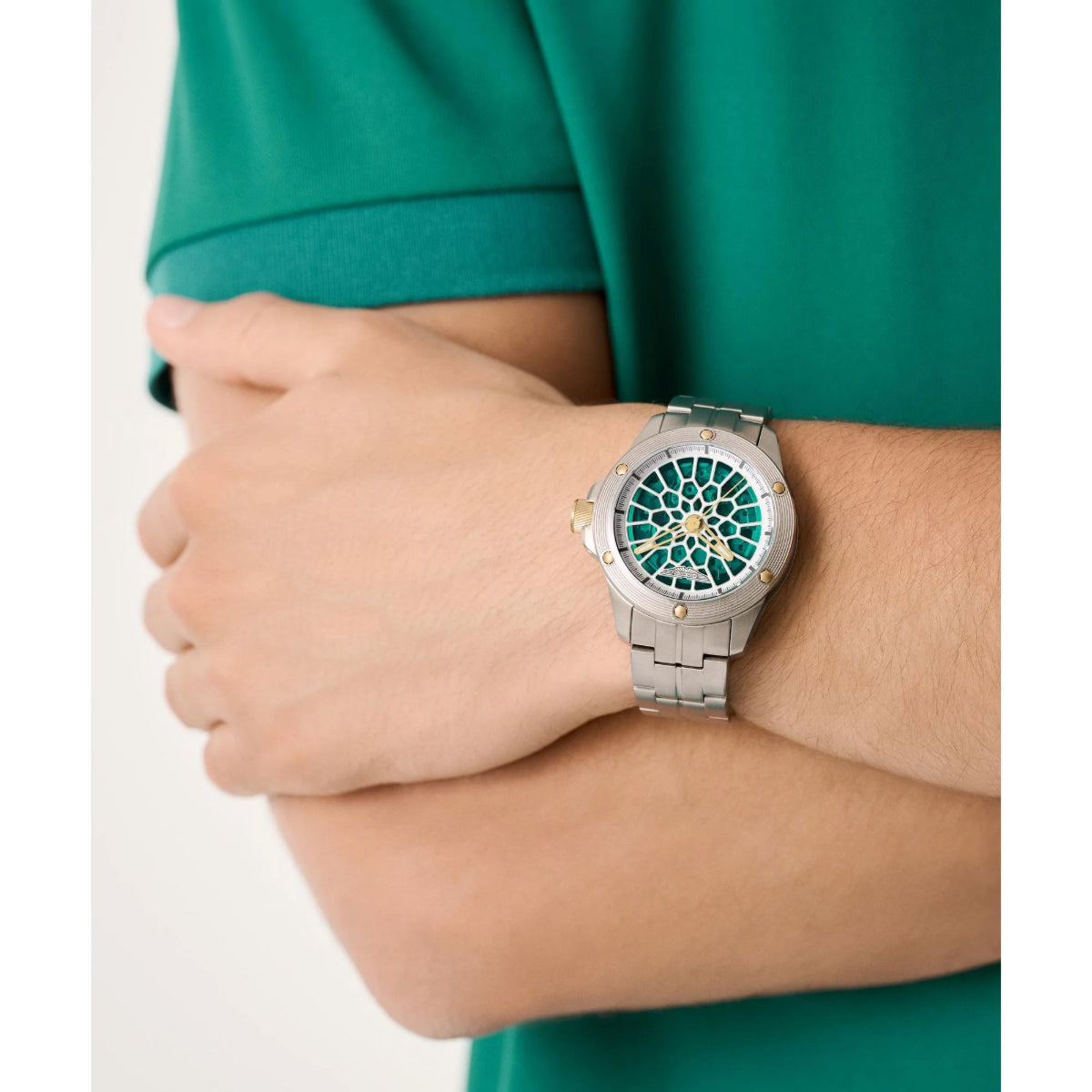 Person wearing a silver watch with a unique face design on a white background