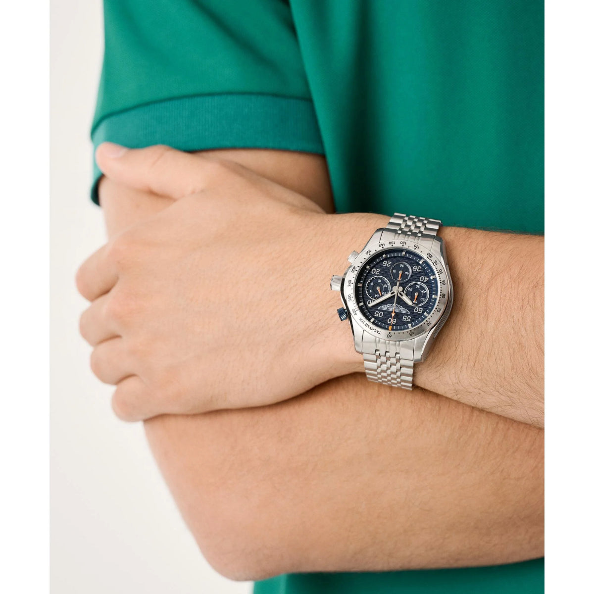 Silver watch on a wrist with a green shirt background