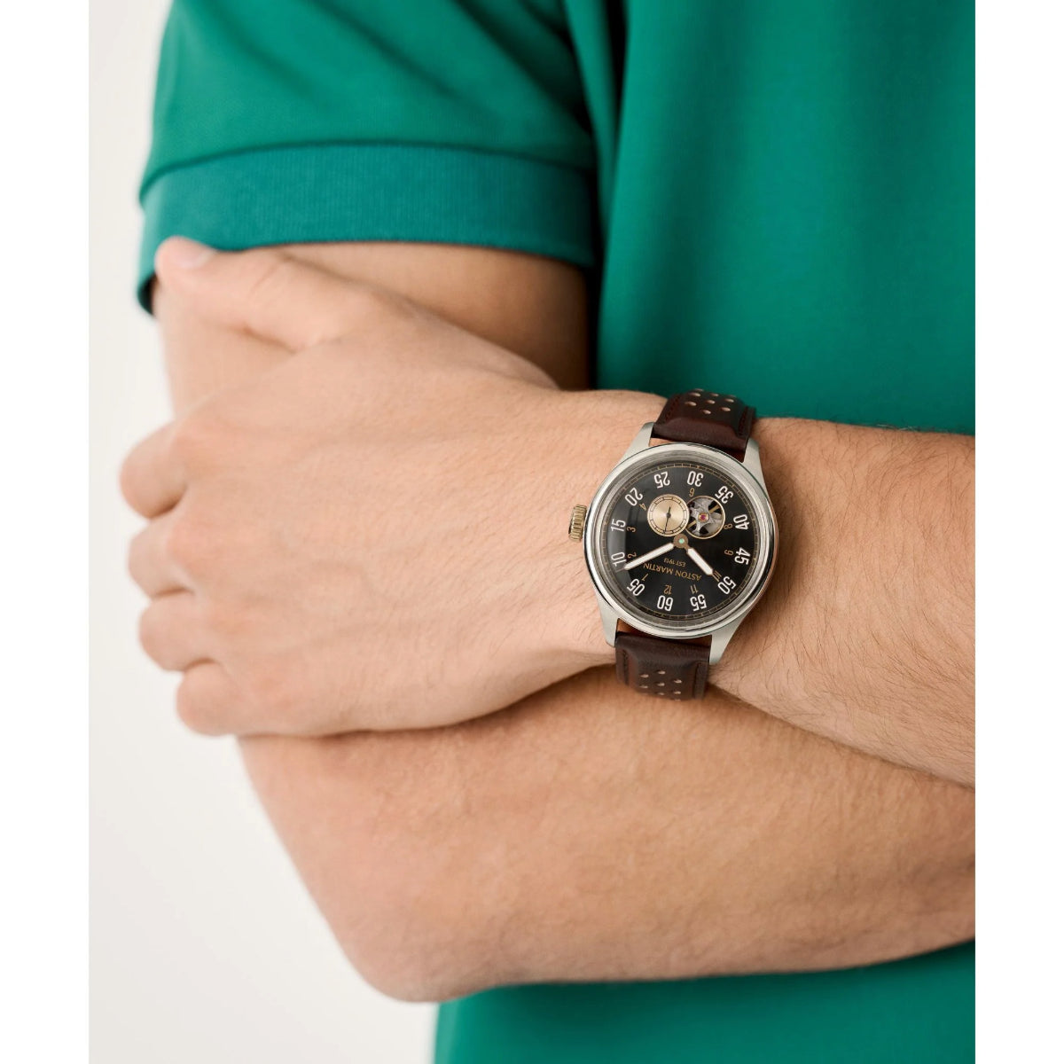 Person wearing a watch with a brown leather strap on a white background