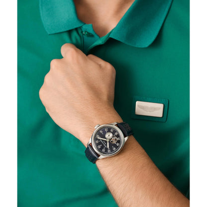 Person wearing a watch with a green shirt featuring a logo.