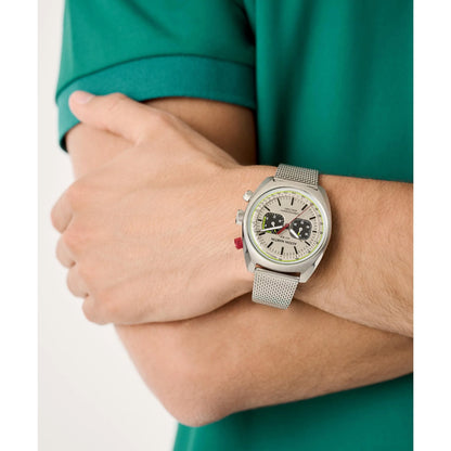 Person wearing a silver watch with a white face on a plain background