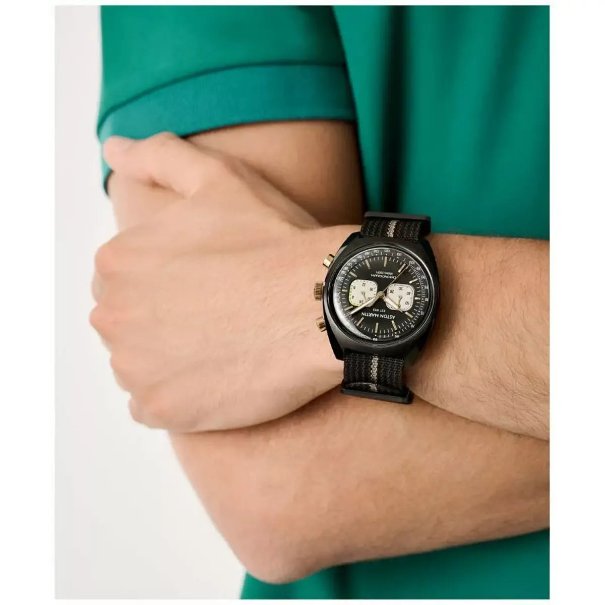 Person wearing a black wristwatch with a green shirt on a white background